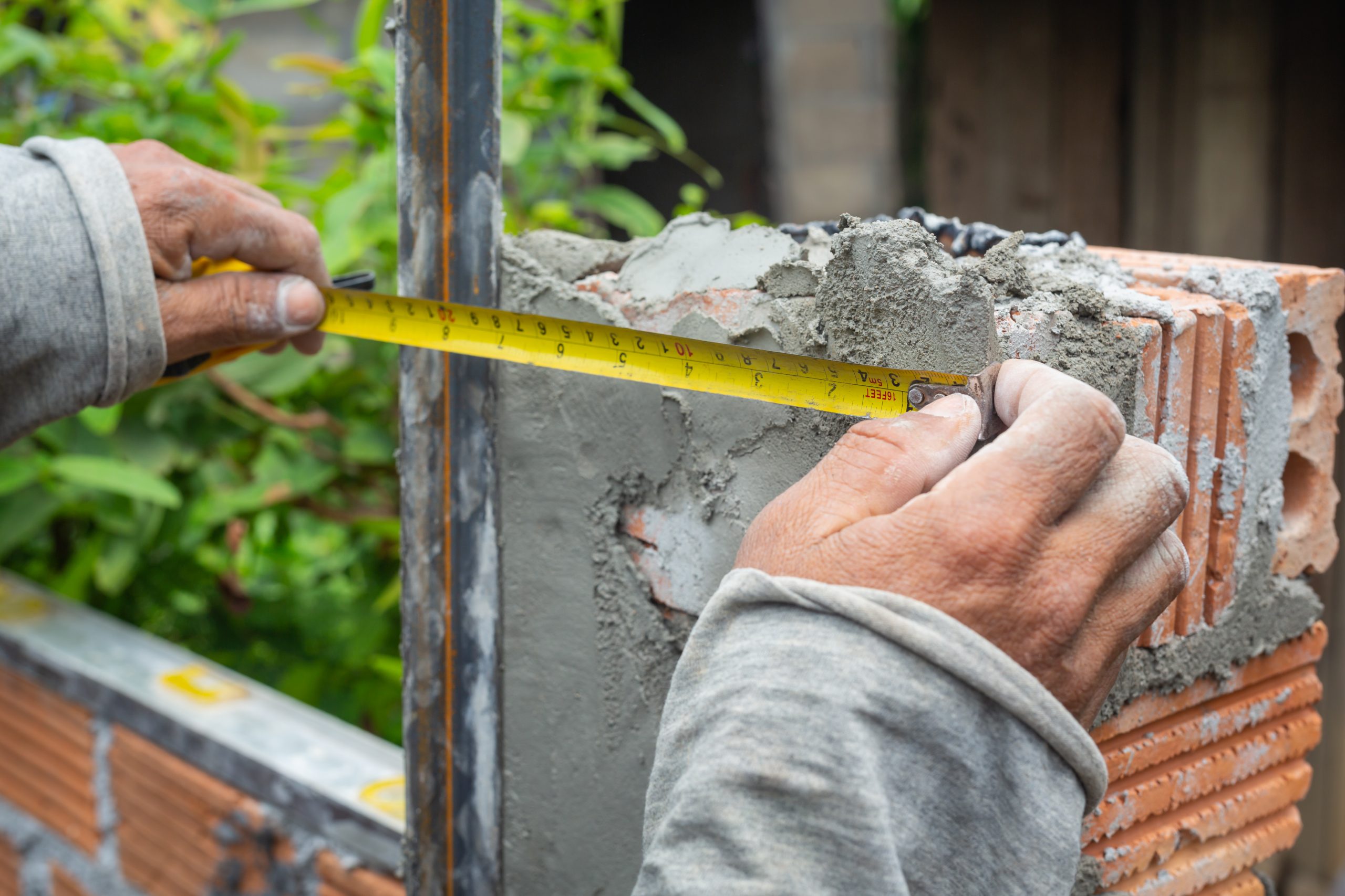 bricklaying construction worker building brick wall scaled